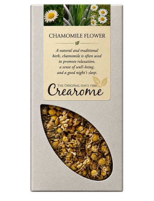 A rectangular cream-colored box of Crearome Chamomile Flower tea, featuring a clear window on the lower half that displays the loose chamomile flowers and leaves inside.