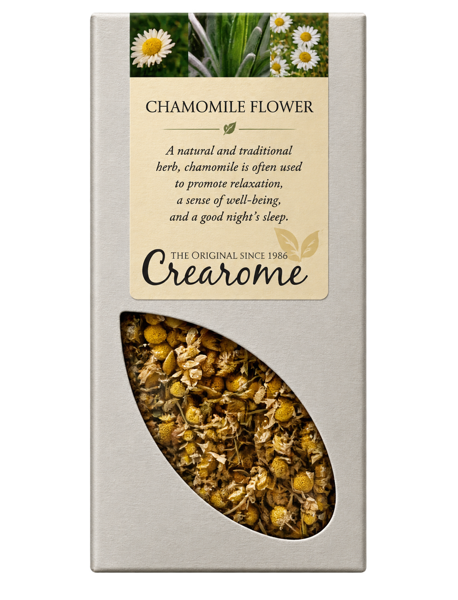 A rectangular cream-colored box of Crearome Chamomile Flower tea, featuring a clear window on the lower half that displays the loose chamomile flowers and leaves inside.